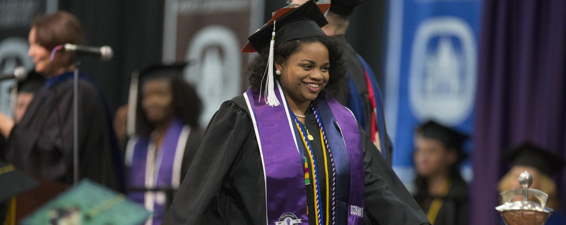 A student crosses the stage at graduation.